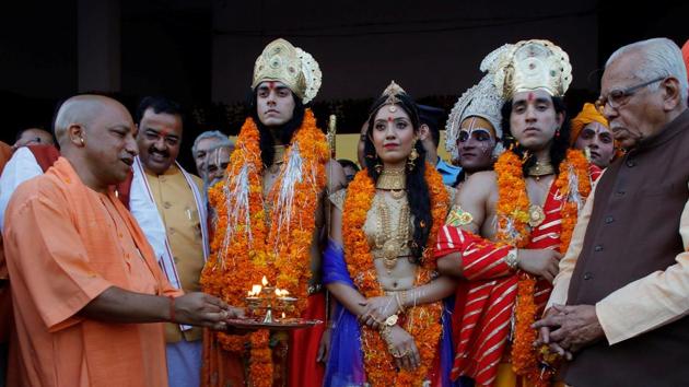 UP chief minister Yogi Adityanath (left) with artists dressed as Rama, his wife Sita and his brother Laxman during Diwali celebrations in Ayodhya, on October 18, 2017.(Reuters Photo)