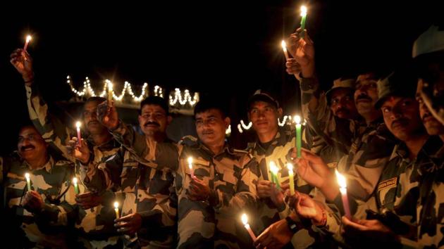 Border security force (BSF) soldiers light candles near the International border fence at Pargwal about 40 kms from Jammu on Tuesday. (PTI)