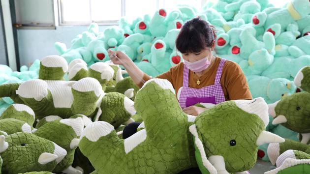 A Chinese employee making stuffed dinosaur toys as they are prepared to export for the upcoming Christmas festive season, at a toy factory in Lianyungang in China's eastern Jiangsu province. (AFP Photo) A Chinese employee making stuffed dinosaur toys as they are prepared to export for the upcoming Christmas festive season, at a toy factory in Lianyungang in China's eastern Jiangsu province. (AFP Photo)