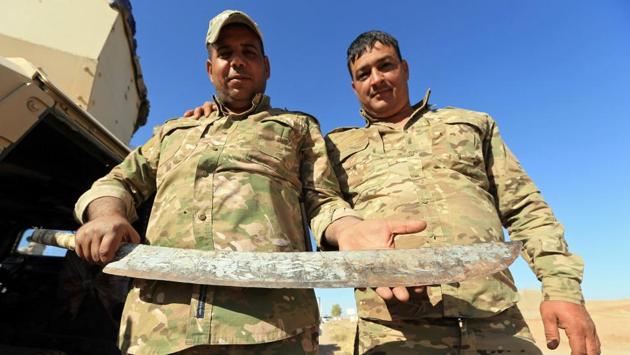 An Iraqi soldier holds a sword which the Iraqi army said belonged to Islamic State fighters, in Zumar, Nineveh province, Iraq on October 18, 2017. (Ari Jalal / REUTERS)