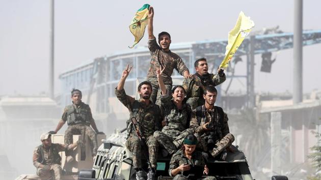 Syrian Democratic Forces (SDF) fighters ride atop military vehicles as they celebrate the liberation of Raqqa from ISIS on October 17, 2017. (Erik De / REUTERS)