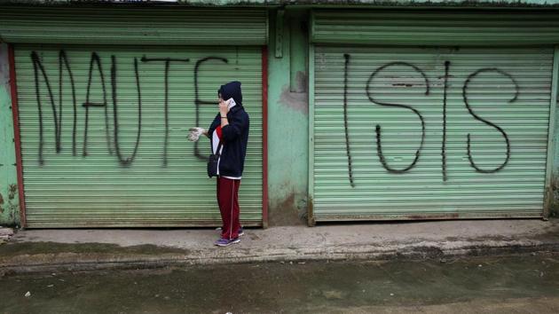 A government worker is seen in front of an establishment marked with a ‘Maute ISIS’ graffiti --a term used for the militant alliance-- during the cleanup drive inside Marawi on October 20, 2017. The mosque-studded Islamic centre in the predominantly Roman Catholic country has been devastated by a siege by militants who waved IS-style black flags and occupied Marawi’s business district and outlying areas, according to the military. (Romeo Ranoco / REUTERS)