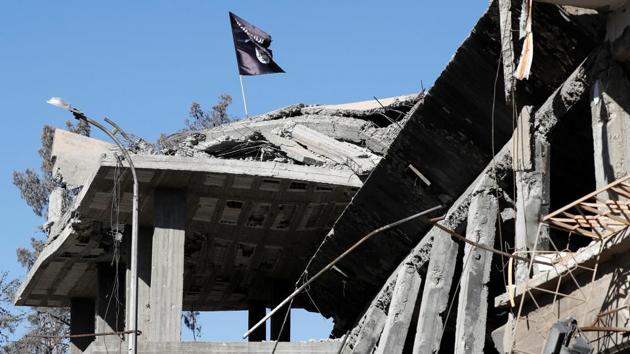 An ISIS flag is pictured above a destroyed house near the Clock Square in Raqqa, Syria on October 18, 2017. The hard-won battles, lasting months have left vast destruction in their wake, and celebrations from atop the rubble of once-grand buildings ring hollow for the hundreds of thousands of displaced residents. (Erik De Castro / REUTERS)