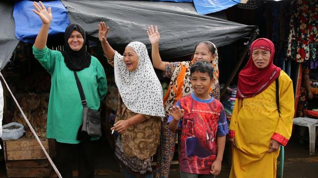 Residents wave at government troops heading back after combatting pro-ISIS groups on October 20, 2017. The insurrection prompted the military to launch a ground offensive and airstrikes, with the US and Australia later deploying surveillance aircraft. Duterte also declared martial law across the south. (Romeo Ranoco / REUTERS)
