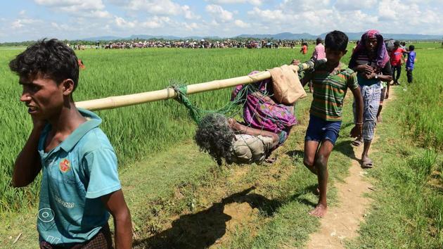 Rohingya refugees walk together after crossing the Naf River as they flee violence in Myanmar to reach Bangladesh in Palongkhali near Ukhia. (Munir Uz Zaman / AFP)