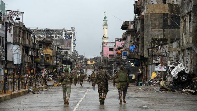 Philippine soldiers walk past destroyed buildings in Bangolo district on October 17, 2017. Defence officials say it could take until January before rebuilding can start, with the heart of the city littered with unexploded bombs, booby traps and buildings on the brink of collapse after months of air strikes. Military operations have cost $97 million and the government estimates it could take 10 times that much to rebuild Marawi. (Ted Aljibe / AFP)
