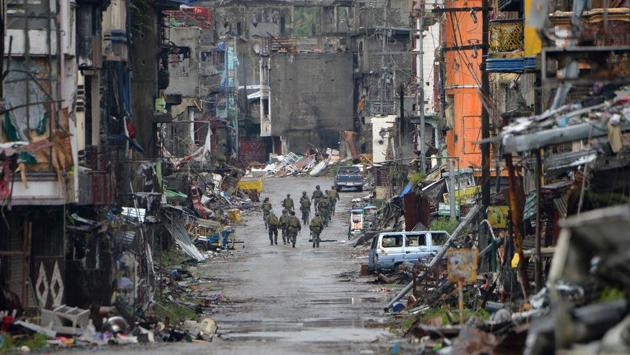 Philippine soldiers walk past destroyed buildings in Bangolo district, after President Rodrigo Duterte declared Marawi City ‘liberated’, in Marawi on October 17, 2017. (Ted Aljibe / AFP)