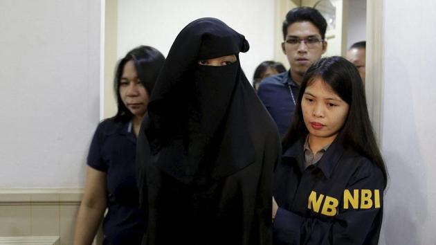 Wearing a burqa, Karen Aizha Hamidon, the widow of the leader of a militant band allegedly sympathetic to the Islamic State group, is escorted by security after a news conference at the National Bureau of Investigation in Manila, Philippines, on October 18, 2017.(AP Photo)