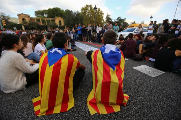 Students wear Esteladas (Catalan separatist flags) as they block a street during a gathering to protest against the imprisonment of leaders of two of the largest Catalan separatist organisations, Catalan National Assembly's Jordi Sanchez and Omnium's Jordi Cuixart, who were jailed by Spain's high court, in Barcelona, on October 17.(Reuters) Students wear Esteladas (Catalan separatist flags) as they block a street during a gathering to protest against the imprisonment of leaders of two of the largest Catalan separatist organisations, Catalan National Assembly's Jordi Sanchez and Omnium's Jordi Cuixart, who were jailed by Spain's high court, in Barcelona, on October 17.(Reuters)