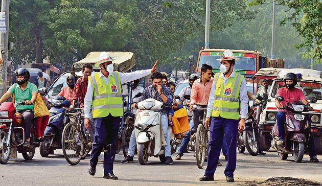 Traffic policemen direct city traffic wearing anti-pollution masks handed out by a private hospital on Saturday. (Parveen Kumar/HT PHOTO) Traffic policemen direct city traffic wearing anti-pollution masks handed out by a private hospital on Saturday. (Parveen Kumar/HT PHOTO)