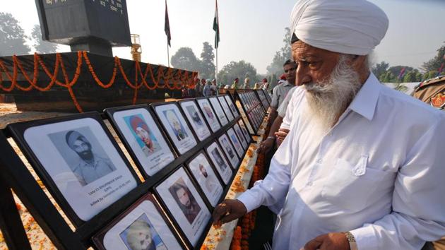 A family member of a martyr looks at the pictures of police martyrs on the occasion of Police Commemoration Day at Jalandhar on Saturday. (Pardeep Pandit/HT)