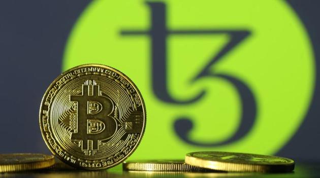 Photo illustration shows copies of Bitcoins seen in front of Tezos logo, October 10, 2017. Picture taken October 10, 2017. (Reuteres) Photo illustration shows copies of Bitcoins seen in front of Tezos logo, October 10, 2017. Picture taken October 10, 2017. (Reuteres)
