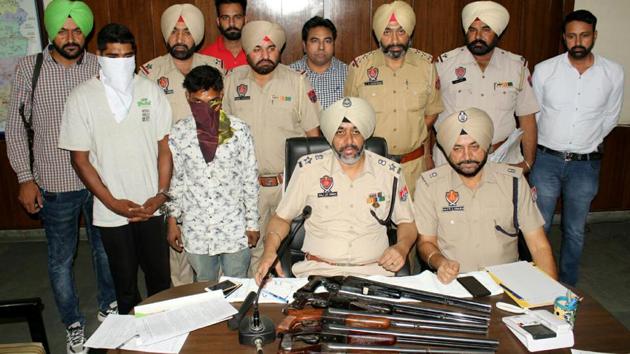 SSP Raj Jit Singh addressing a press conference with the arrested accused standing behind him (with covered faces) and the guns on his table in Moga on Saturday. (HT Photo) SSP Raj Jit Singh addressing a press conference with the arrested accused standing behind him (with covered faces) and the guns on his table in Moga on Saturday. (HT Photo)