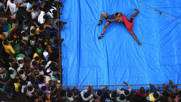 Indian amateur wrestlers participate in a friendly wrestling competition on a make-shift ring at the junction of a busy road, Rajakatra, Burrabazar, as part of Diwali festivities in Kolkata on October 18. (Dibyangshu Sarkar / AFP) Indian amateur wrestlers participate in a friendly wrestling competition on a make-shift ring at the junction of a busy road, Rajakatra, Burrabazar, as part of Diwali festivities in Kolkata on October 18. (Dibyangshu Sarkar / AFP)
