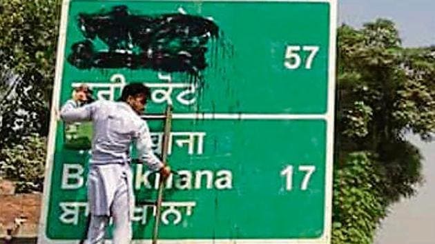 Activists of Dal Khalsa, SAD (Amritsar), smudging the signboards written in Hindi and English on Saturday.(HT Photo)