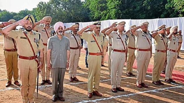 Chandigarh DGP Tajender Singh Luthra (first from left) along with other police officers salute the martyrs.(Karun Sharma/HT)