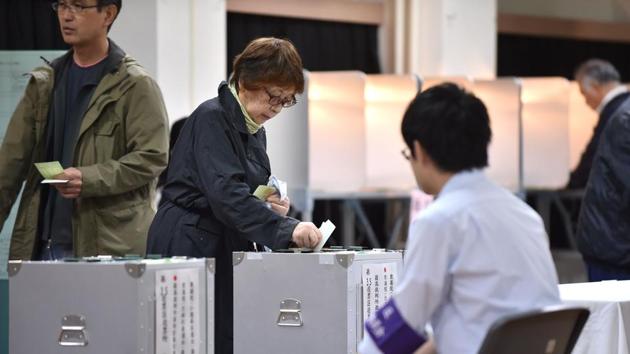 A woman casts her vote in Japan's general election at a polling station in Tokyo on october 22, 2017.(AFP Photo)