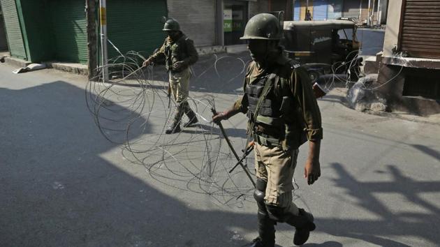 File photo of paramilitary soldiers closing a street with a barbwire during a strike called by separatists.(AP File Photo)