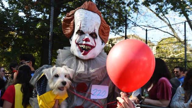 Fear...never heard the word! Causally hanging out with Pennywise the clown is clearly no biggie for this canine. (Timothy A. Clary / AFP)
