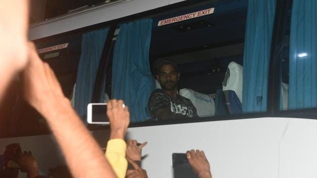Residents taking mobile photographs of Indian cricket player Shikhar Dhawan sitting in the team bus outside Kedar Jadhav's house in Kothrud in Pune.  (Pratham Gokhale/HT Photo) 