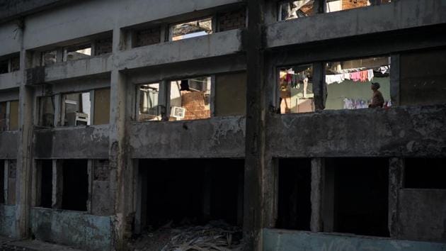 A man stands inside a building that used to house the Brazilian Institute of Geography and Statistics (IBGE), and is now occupied by hundreds of squatters in Rio de Janeiro’s Mangueira slum. Non-labor income, including social programs like Bolsa Familia, accounted for nearly 60 percent of the reduction in the number of people living in extreme poverty during the boom decade, said Emmanuel Skoufias, a World Bank economist. (Felipe Dana / AP)