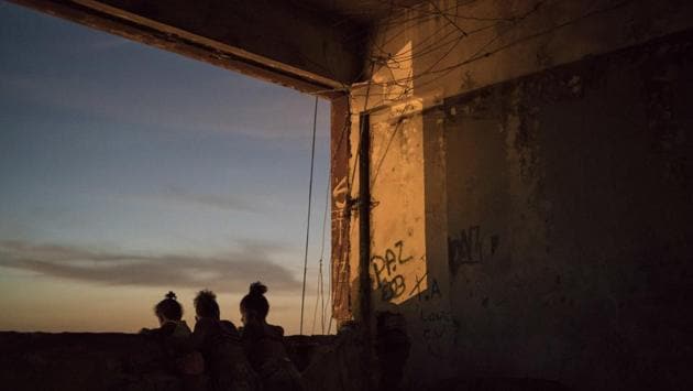 Children look out of an empty window of a building where hundreds of squatters live in the Mangueira slum in Rio de Janeiro. For many who live in Rio’s hundreds of favelas or slums, an already hardscrabble existence feels increasingly precarious. (Felipe Dana / AP)