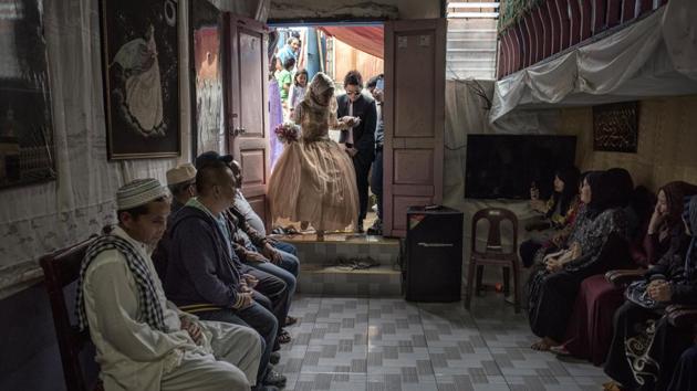 The bride and groom enter the room where there wedding ceremony took place in Saguiaran, Philippines. Displaced Marawi residents made the best of this situation after the fierce urban battle. (Jes Aznar / Getty Images)