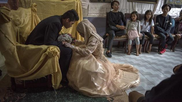 Bride Katty Malang Mikunug (R ), kneels before Paulo Mamayo Ambor, 22, during their wedding on October 21, 2017, in Saguiaran, southern Philippines. Paulo, a resident of Marawi who was displaced by fighting between government troops and IS-inspired militants, wed Katty Mikunug, a resident of an adjacent town in Saguiaran. (Jes Aznar / Getty Images)
