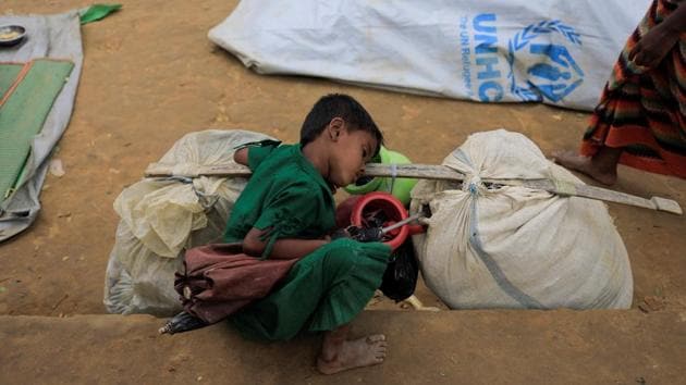 A Rohingya refugee girl sleeps beside her family’s belongings while taking shelter at a school in Kotupalang refugee camp near Cox's Bazar on October 21, 2017. (Zohra Bensemra / REUTERS)