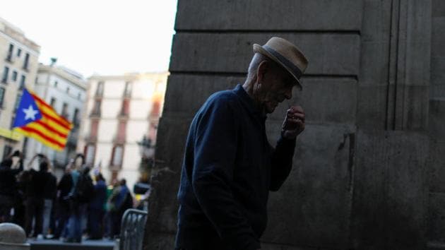 An old man walks as protestors wave an Estelada (Catalan spearatist flag) at Sant Jaume square in Barcelona on Wednesday. (Reuters Photo) An old man walks as protestors wave an Estelada (Catalan spearatist flag) at Sant Jaume square in Barcelona on Wednesday. (Reuters Photo)