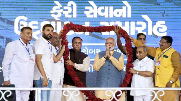 Prime Minister Narendra Modi being welcomed on stage at the public meeting in Ghogha, Gujarat on October 22. Chief minister Vijay Rupani and deputy chief minister Nitinbhai Patel are also seen.(PTI Photo)