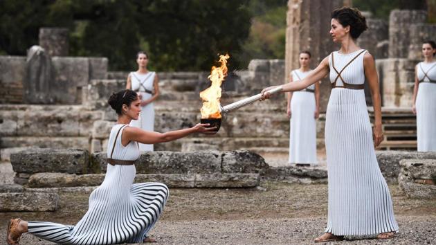 Actress Katerina Lechou (R), portraying the high priestess, lights the Olympic flame at the Temple of Hera in Olympia --the sanctuary where the Olympic Games were born in 776 BC--during the lighting ceremony of the Olympic flame for the 2018 Winter Olympics to be held in Pyeongchang, South Korea. The 2018 Winter Olympics will take place between February 9 to February 25. (Aris messinis / AFP)