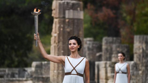 Katerina Lechou (L), acting the high priestess, holds the Olympic flame at the Temple of Hera. From the rain-soaked valley of Ancient Olympia, where the Games of antiquity were held for more than a thousand years, the flame will course through Greece for eight days and reach South Korea on November 01, 2017. (Aris messinis / AFP)