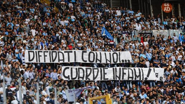 In this Oct. 1, 2017 file photo, Lazio fans display a banner reading in Italian "Banned fans with us, vile cops" during a Serie A soccer match between Sassuolo and Lazio at the Olympic stadium in Rome. Lazio fans have a long history of racism and anti-Semitism but the Roman club's supporters established a new low on Sunday, Oct. 22, 2017 when they littered the Stadio Olimpico with superimposed images of Anne Frank, the young diarist who died in the Holocaust, wearing a Roma jersey.(AP)