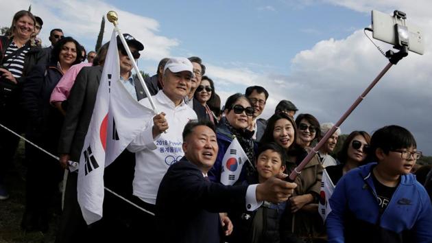 Spectators take selfies during the Olympic flame lighting ceremony for the 2018 Winter Olympics to be held in Pyeongchang. (Costas Baltas / REUTERS)