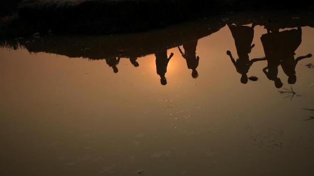 Silhouettes of Rohingya refugees are reflected in a pond as they walk through Palong Khali refugee camp at sunrise, near Cox's Bazar on October 24, 2017. (Hannah McKay / REUTERS)