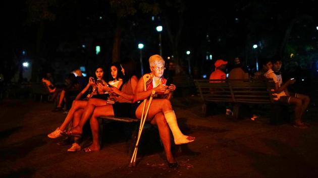 People connect to the internet at an outdoor hotspot in Havana, Cuba. At dusk, when the worst of the Caribbean heat has subsided, parks around Cuba fill with families video chatting with loved ones abroad or scrolling through social media --their animated faces lit by telephone and tablet screens. (Alexandre Meneghini / REUTERS)
