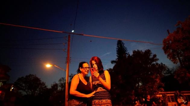 Claudia Espinosa, 20 (R), and her mother Maribel Sosa, speak to relatives in the US at a hotspot in Havana. ‘A lot has changed,’ said 54-year-old Sosa, having stood for an hour at the corner of a park, laughing and gesticulating at her phone’s screen. She recalled how queuing all night to use a public telephone to speak with her brother for a few minutes after he emigrated to Florida in the 1980s. (Alexandre Meneghini / REUTERS)