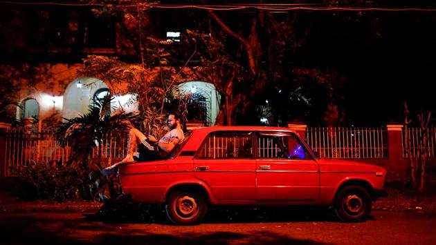 Tourist guide Daniel Hernandez, 26, sits on his Russian-made car speaking to his girlfriend who lives in Britain, at a hotspot in Havana. ‘There’s absolutely no privacy here,’ said Hernandez. ‘When I have sensitive things to talk about, I try shutting myself into my car and talking quietly.’ (Alexandre Meneghini / REUTERS)