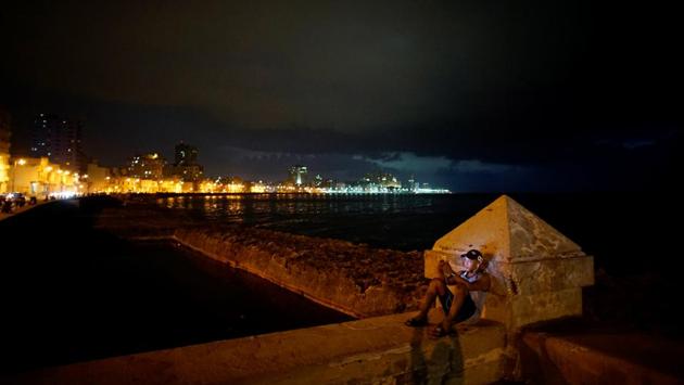 A man connects to an internet hotspot at the sea front at the Malecon in Havana. The quality of connections is often good only at specific spots and when fewer users are connected. Otherwise, the screen tends to freeze mid-chat. (Alexandre Meneghini / REUTERS)