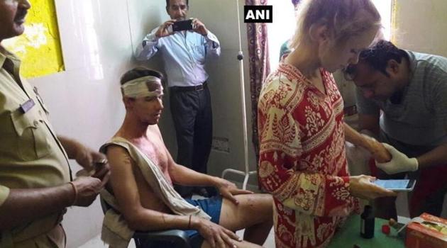 The Swiss couple who was attacked allegedly by a group of men with sticks and stones getting medical attention.(ANI/Twitter)