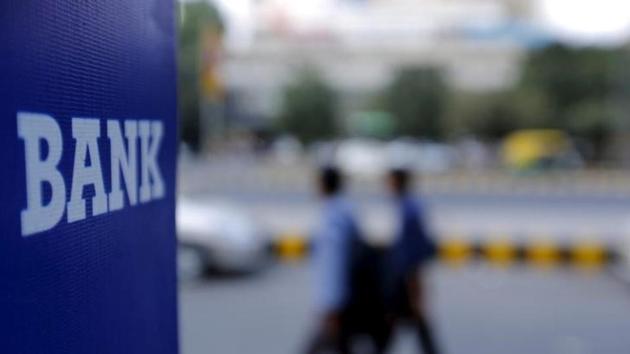 Commuters walk past a bank sign along a road in New Delhi. (Reuters File Photo) Commuters walk past a bank sign along a road in New Delhi. (Reuters File Photo)
