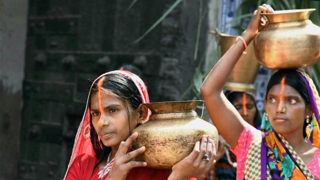 In Bodhgaya Hindu devotees carry holy water from the river Falgu as part of festive rituals on the occasion oh 'Chhath Puja' on Wednesday. (PTI)