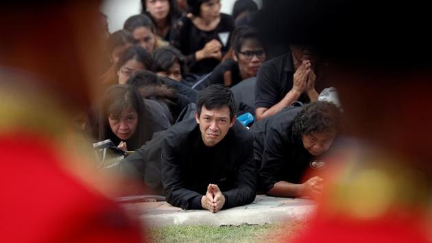 Mourners prostrate as the cremation procession of late King Bhumibol Adulyadej passes by the Grand Palace in Bangkok on October 26, 2017. As the urn passed them, many mourners fully prostrated on the ground, a once abolished practice brought back during Bhumibol’s reign, while others burst into tears. (Damir Sagolj / REUTERS)
