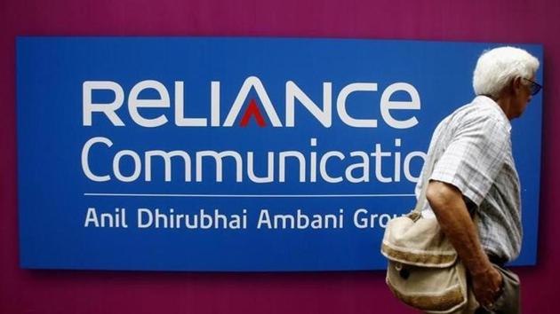 A man walks past a logo of Reliance Communication before the Annual General Meeting in Mumbai September 22, 2009. (Reuters File Photo)