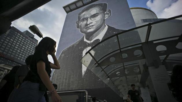 An image of the late Thai King Bhumibol, who many Thais loved like a father, covers the side of a building in Bangkok. As Thailand prepared for the elaborate cremation ceremony, his image was omnipresent across the country from billboards to ATM screens, from full-page tributes in national newspapers to commemorative books in street-side markets and shrines in shopping malls to exhibits in art galleries. (Charles Dharapak / AP)