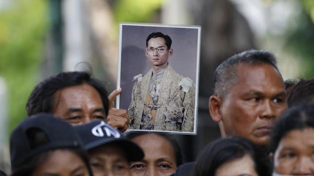 A Thai mourner holds up the portrait of the late King Bhumibol Adulyadej near the Grand Palace to take part in the Royal Cremation ceremony in Bangkok on October 25, 2017. An elaborate five-day funeral is underway for the late king with his son and incumbent ruler performing Buddhist merit-making rites in preparation for moving Bhumibol’s remains to a spectacular golden crematorium. (Sakchai Lalit / AP)