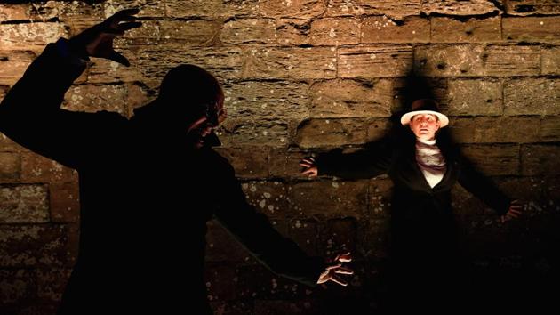 During a performance Richard Hollick acting as Dracula (L) stalks a victim (R) while the spectacular light display illuminates the Abbey’s ruins. (Ian Forsyth / Getty Images) 