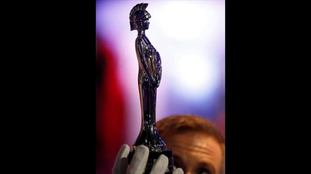 A Brit award for best artist won by Prince in 1995 is held by a curator at the ‘My Name Is Prince’ exhibition in London, Britain. (Peter Nicholls / REUTERS)