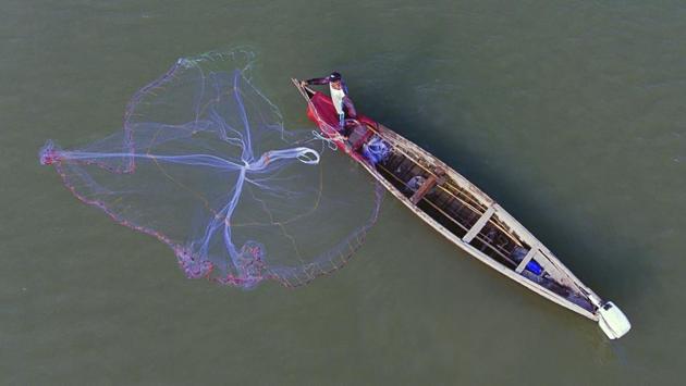 A fisherman casts his net into the Chabaish marsh in Nasiriyah, Iraq. Upstream electrical dams and irrigation projects have reduced the flow of freshwater, allowing saltwater from the Persian Gulf to seep in. (Nabil al-Jurani / AP)
